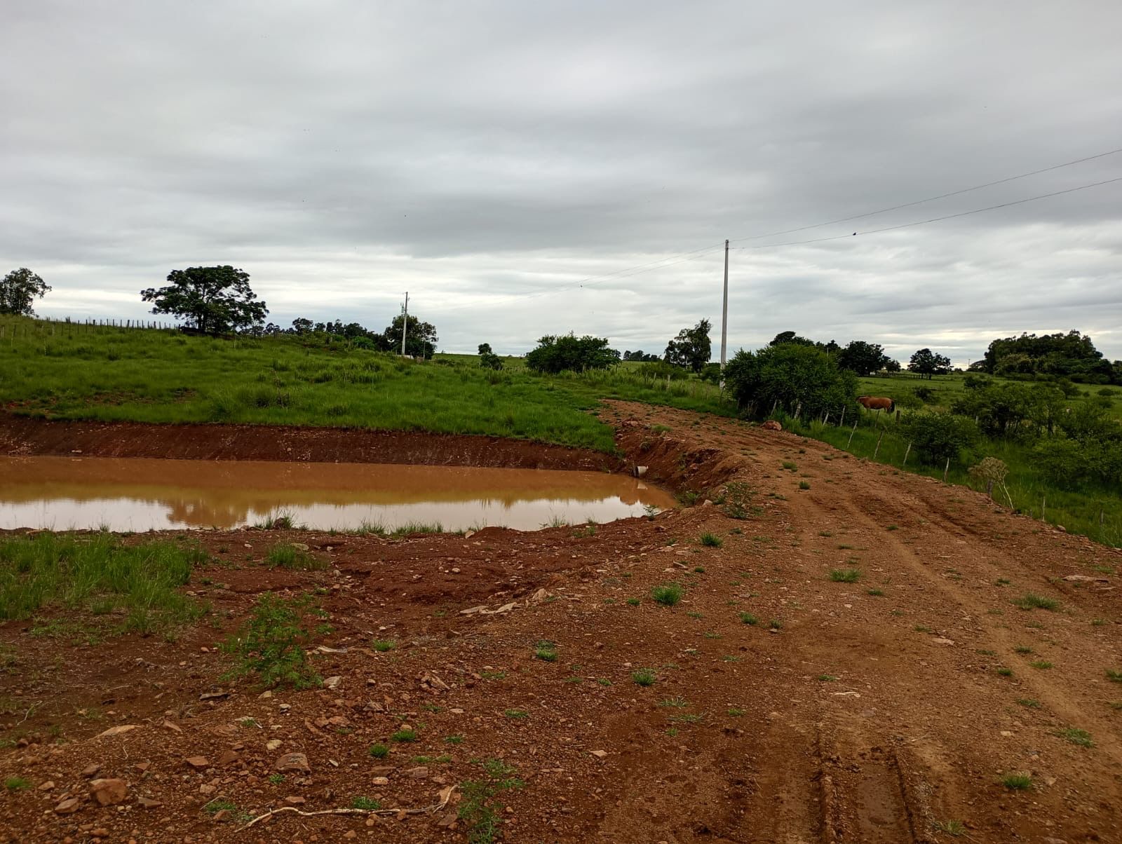 Obras rurais — açude construído com abertura de acesso e taipa ao redor