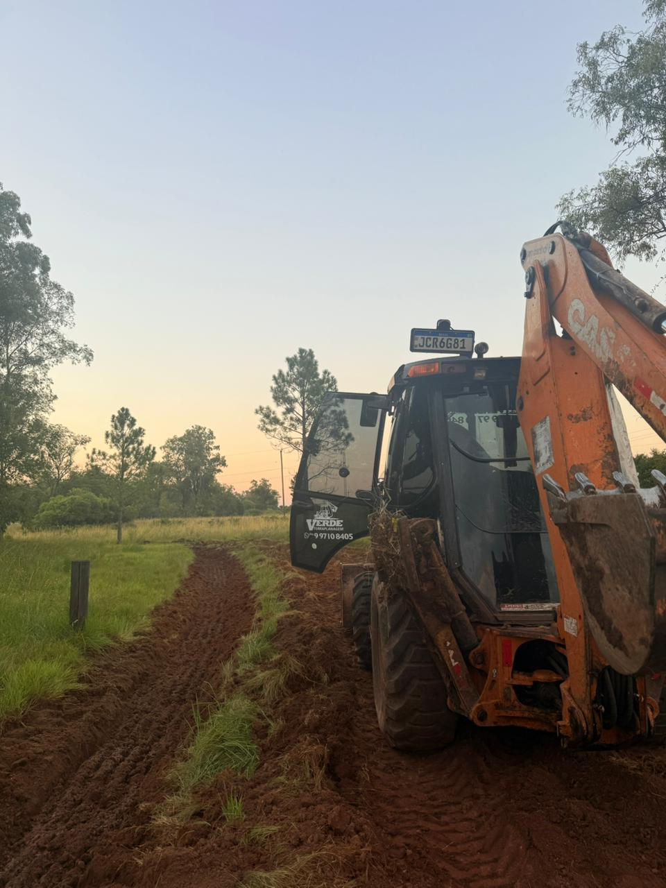 Escavação de vala — retroescavadeira abrindo vala de drenagem no campo